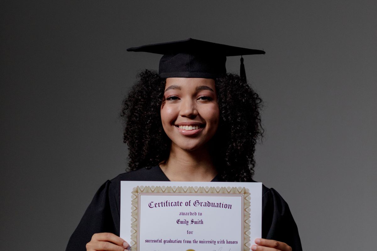 A graduate in a gown holding her certificate