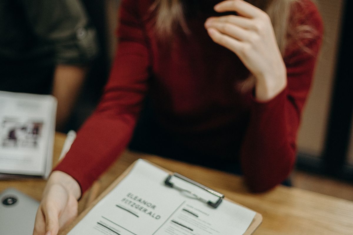 A professional reviewing application documents on a clipboard