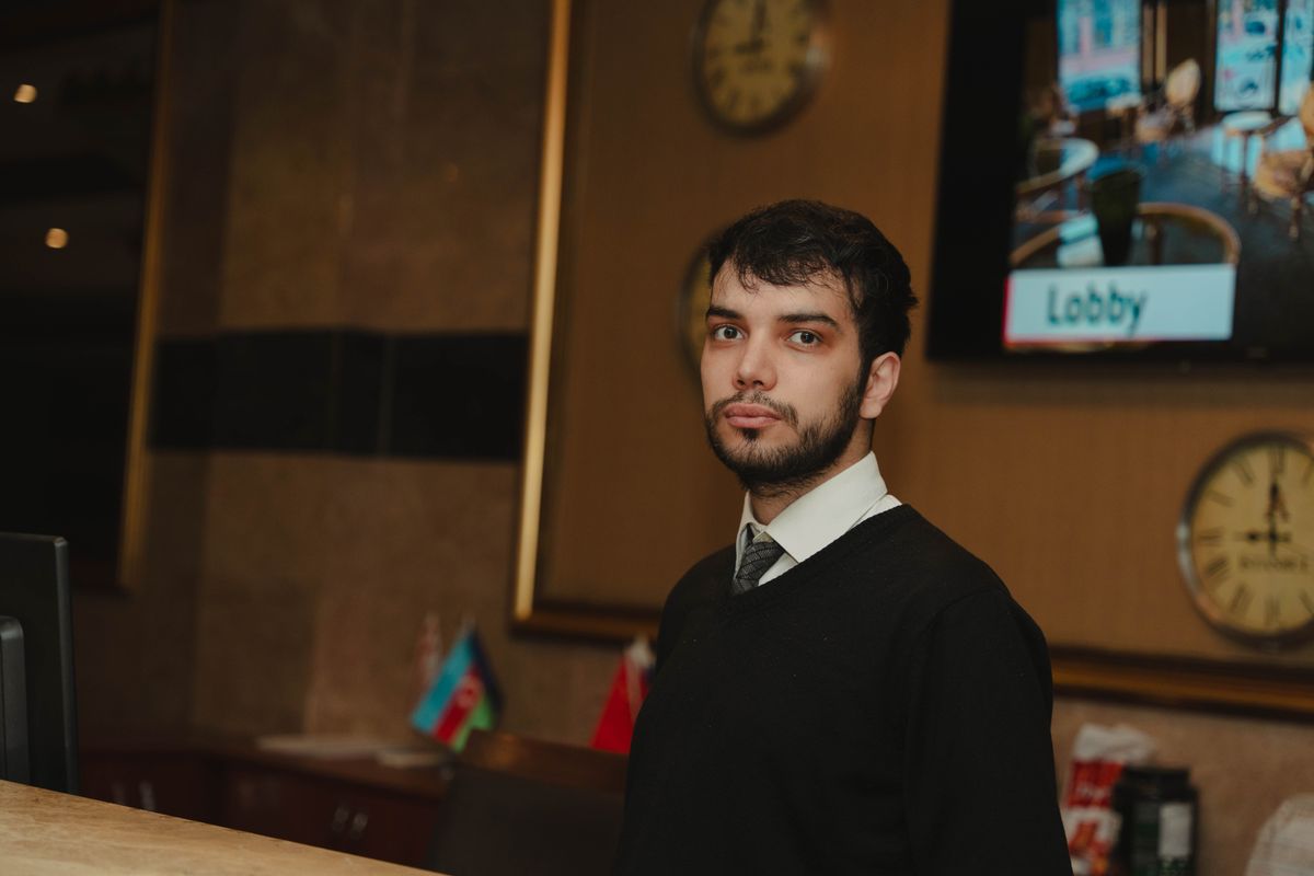 A hotel receptionist ready to welcome guests at the front desk