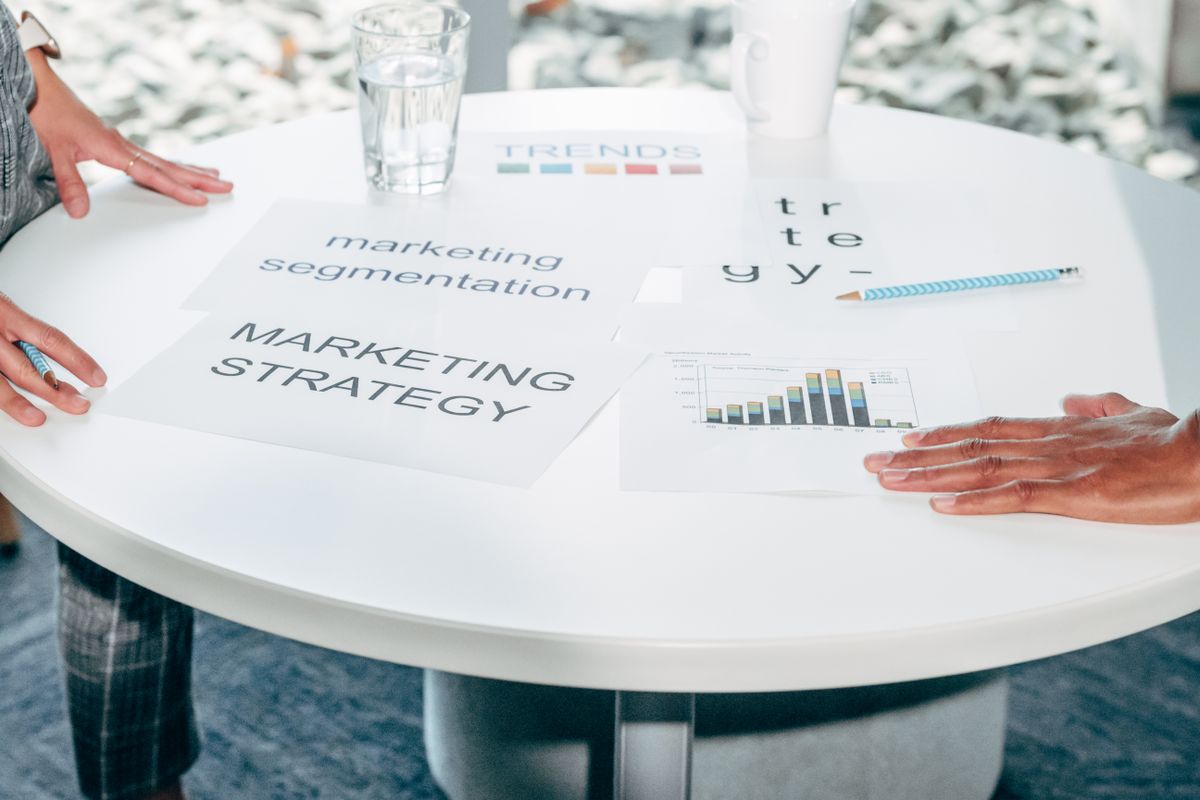 Two professionals discussing marketing strategy documents at a table